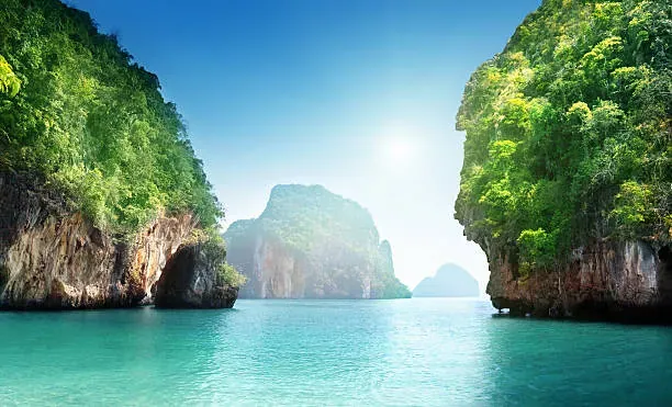 Turquoise water winding between jungle-covered limestone cliffs in a Krabi island lagoon