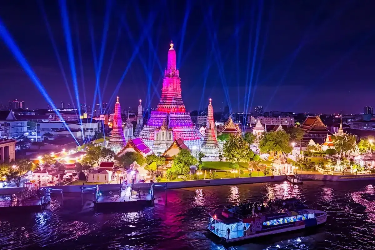 Wat Arun lit up at night, seen from a Chao Phraya river cruise boat in Bangkok
