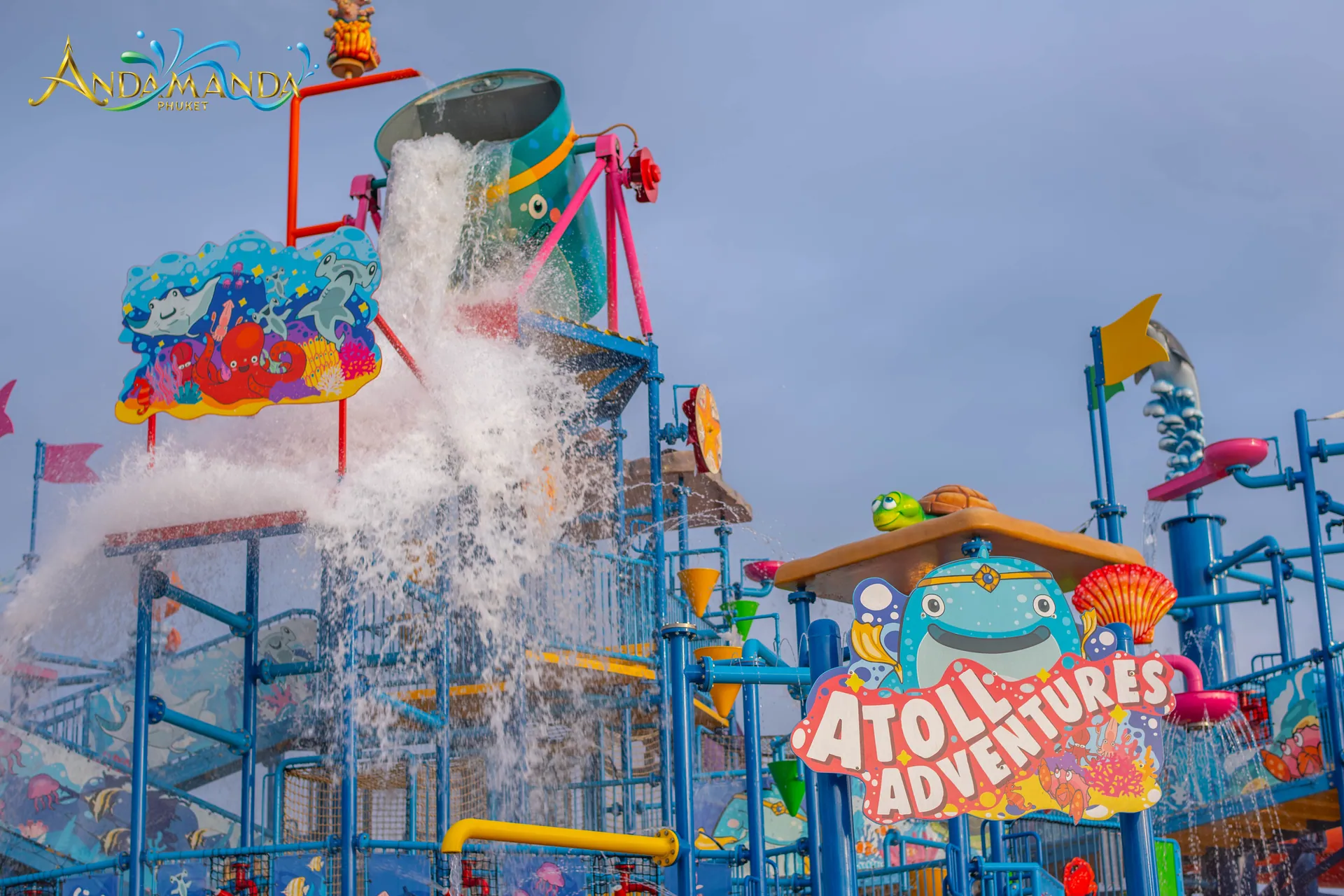 Water tipping from a giant bucket over the Atoll Adventures splash playground at Andamanda Phuket water park