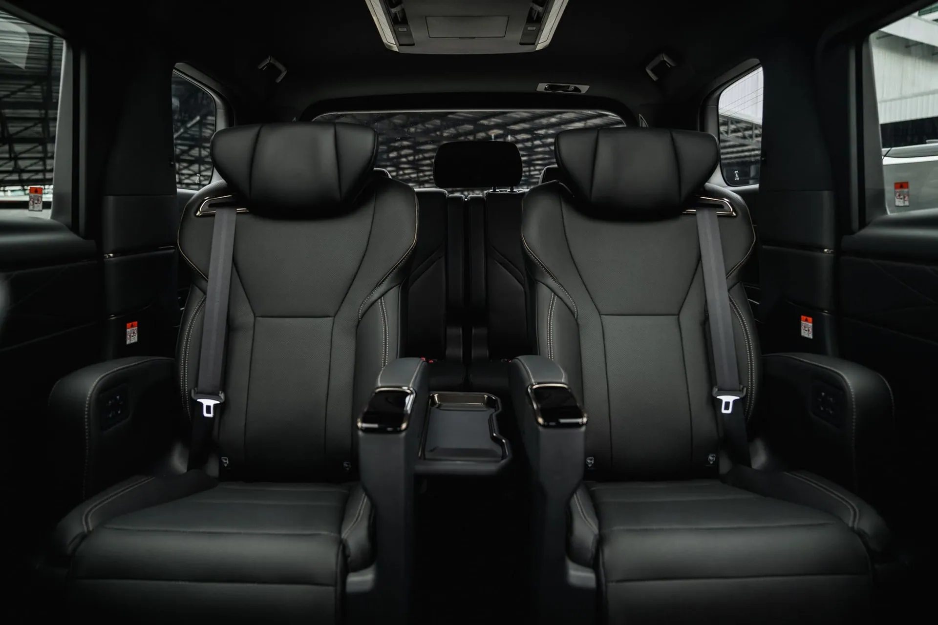 Two black leather captain’s seats in the second row of a Toyota Alphard